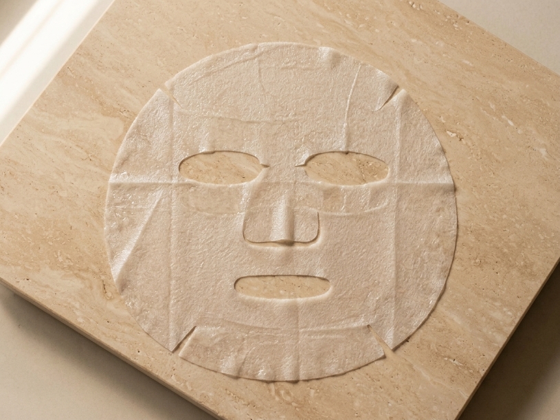 Tissue mask Ardaraz de ácido hialurónico sobre superficie de travertino — estudio independiente de hidratación